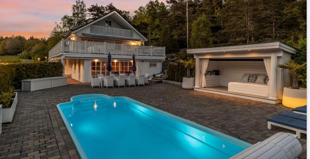 a backyard with a swimming pool and a house at Spacious villa with heated pool and stunning view in Tokenes