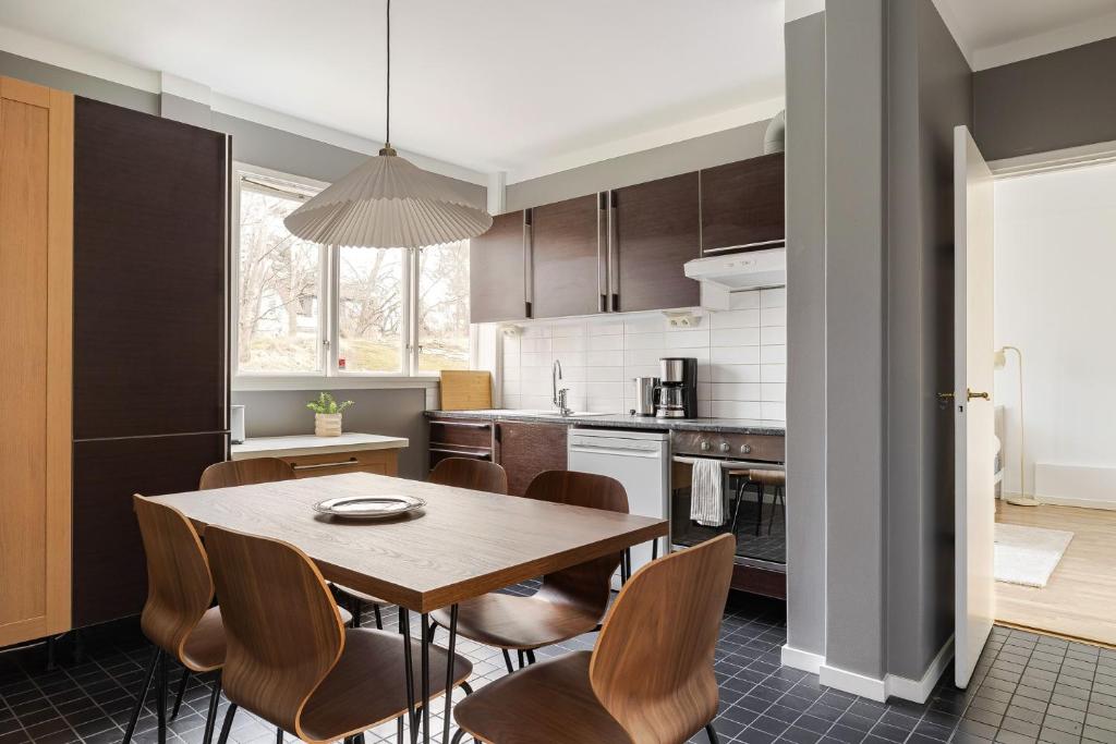 a kitchen with a wooden table and chairs at Chic 2-Bedroom apartment on Lidingö in Lidingö