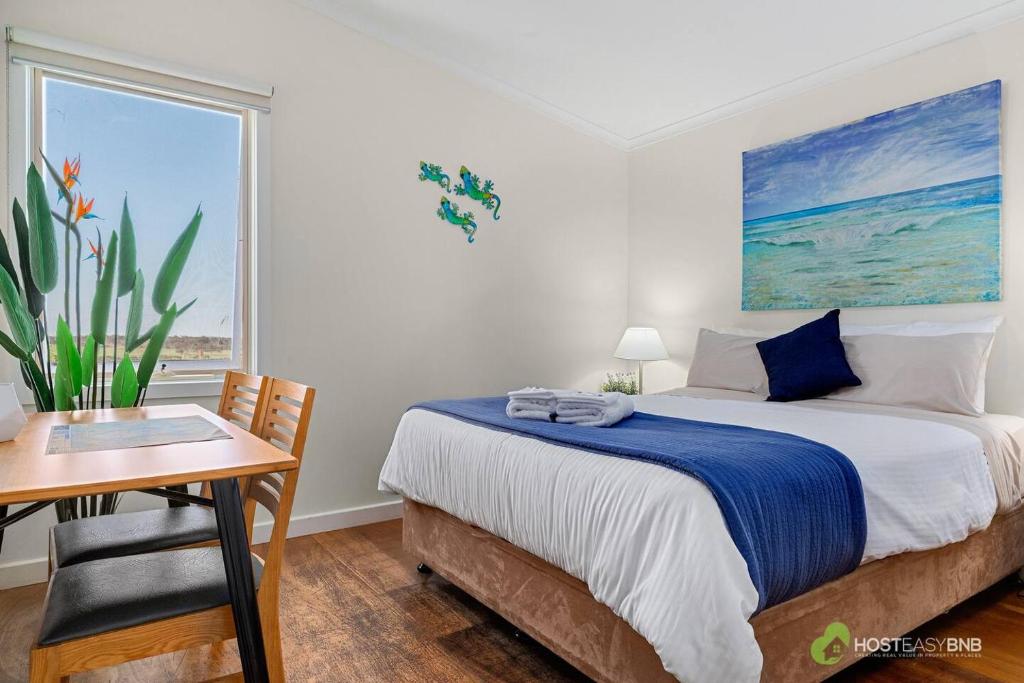 a bedroom with a bed and a desk and a window at Phillip Island Resort Villa 148 Amazing Views in Cowes