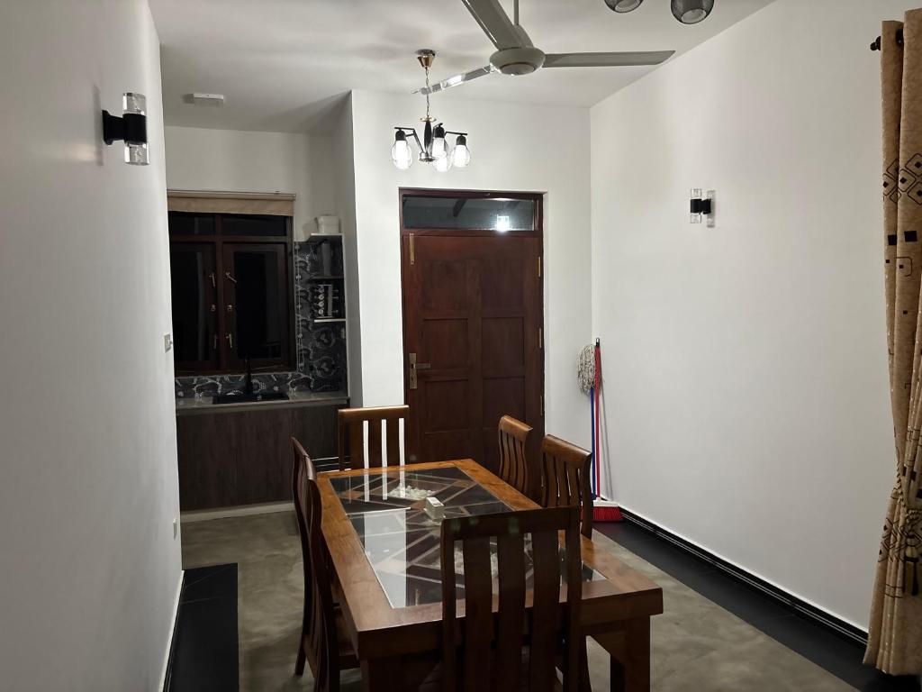 a dining room with a wooden table and chairs at Lanka Villa Beruwala in Beruwala