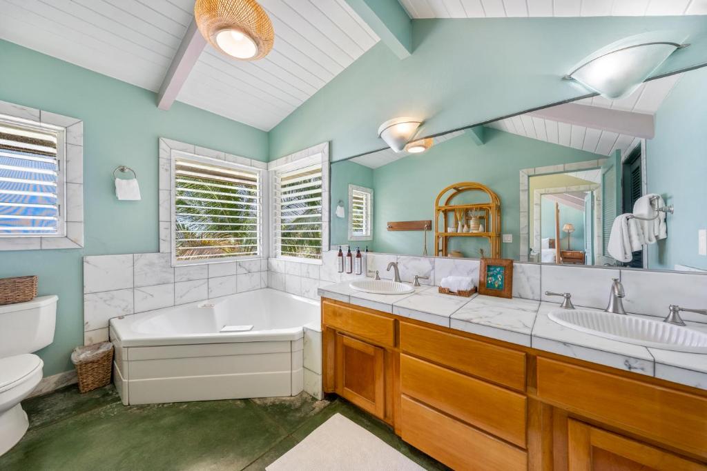 a bathroom with two sinks and a tub and a toilet at Hale Kepuhi in Hanalei