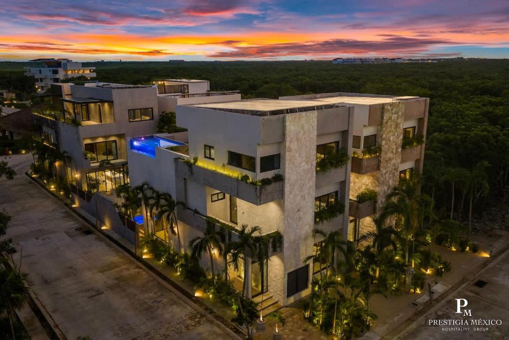 an aerial view of a building with palm trees at Piedras Luxe by Prestigia - Villa in Tulum