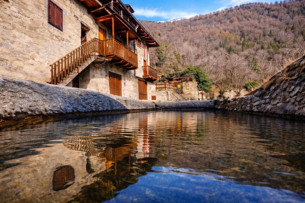 a building next to a river with a reflection in the water at Maison Champriond in Rif