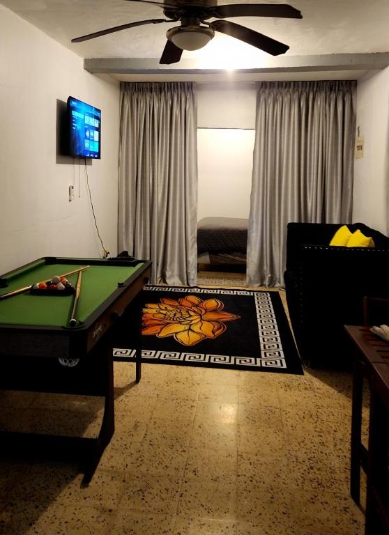 a living room with a pool table and a tv at First Floor 2 Bed Apartment in La Ceiba
