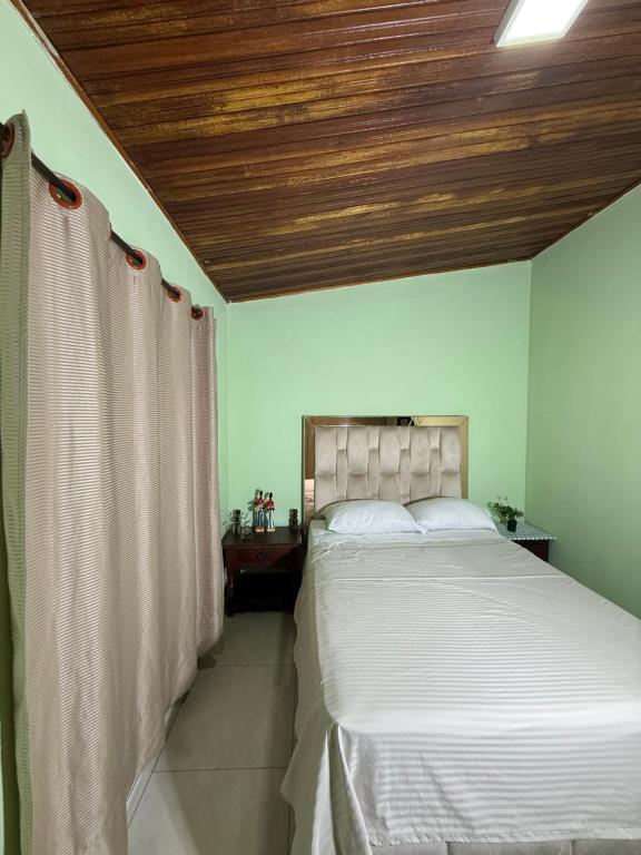 a bedroom with a large bed with a wooden ceiling at Aquarium Rooms in Floridablanca