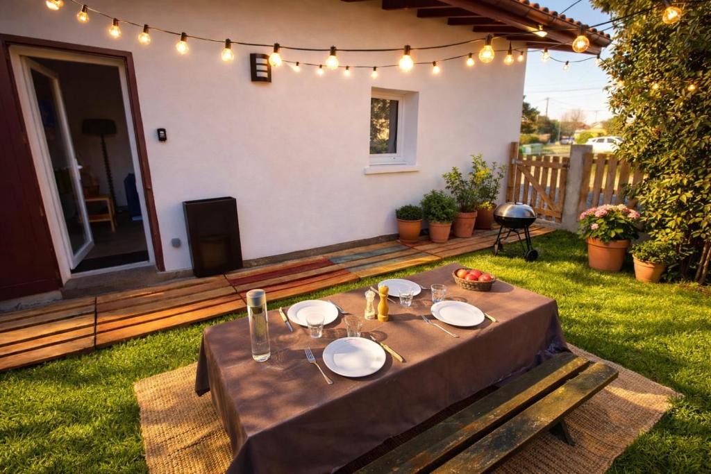 a table with plates on it in a yard at Studio indépendant avec jardinet in Tarnos