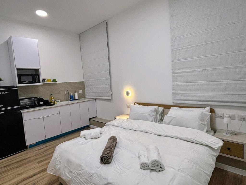 a bedroom with a large white bed with towels on it at Koresh 10 -revelin suite in Jerusalem