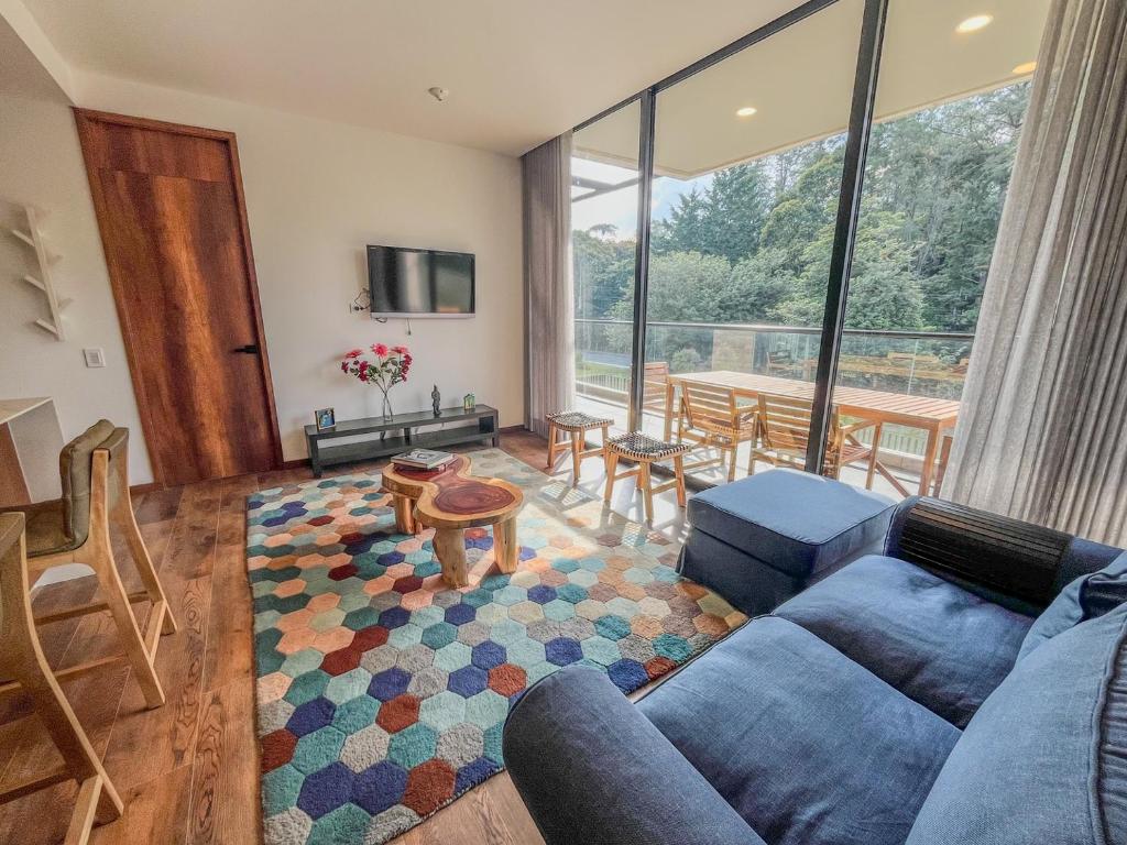 a living room with a blue couch and a table at Upscale 2BR Countryside Suite | Stylish & Modern in El Retiro