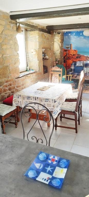 a table and two chairs on a patio at Coeur de granit rose, meublé alliant le charme de l'authentique breton et du confort, classé 3 étoiles, à 5mn de 13 plages de la réputée cote de granit rose in Trégastel