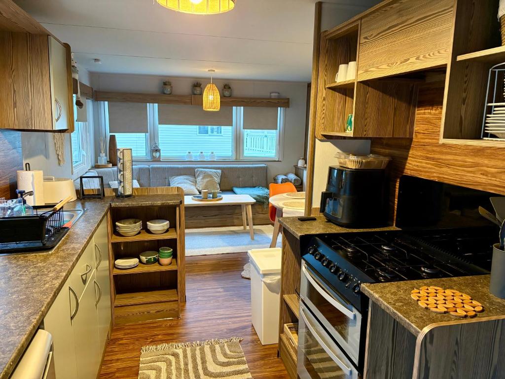 a kitchen with a stove and a living room at Jazmine's Place in Ayr