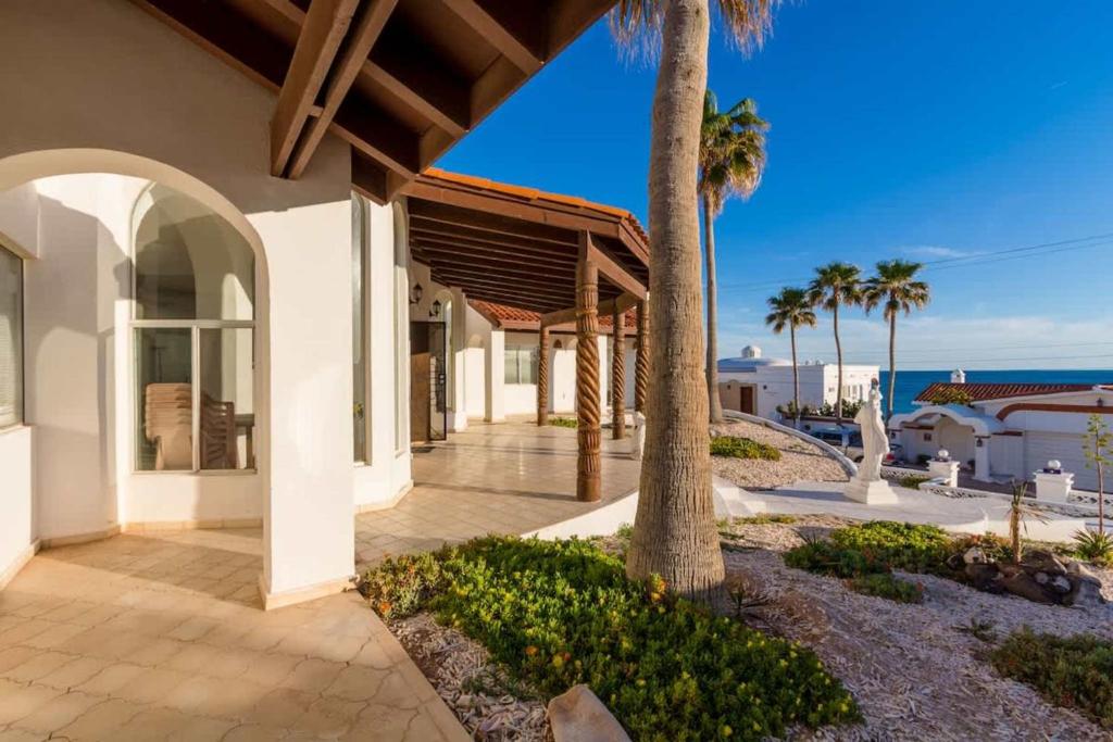 a house with a palm tree and a walkway at Recently Renovated Oceanview Home Casa Hebe in Puerto Peñasco