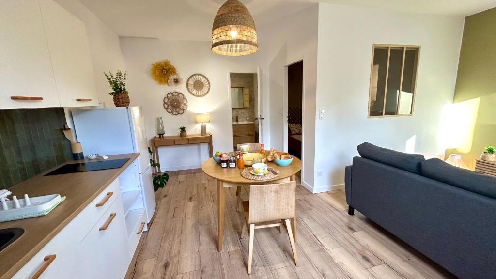 a kitchen and living room with a table and a couch at Casa Sole in Saint-Chamond