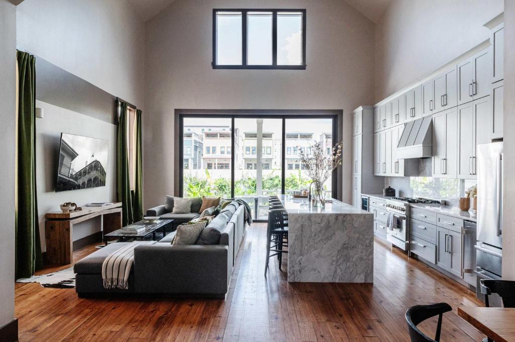 a large living room with a couch and a kitchen at Expansive 7 Bedroom Home Heated Pool & Spa in New Orleans