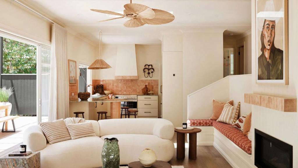 a living room with a white couch and a ceiling fan at Designed By Three Birds Renovation in Pearl Beach