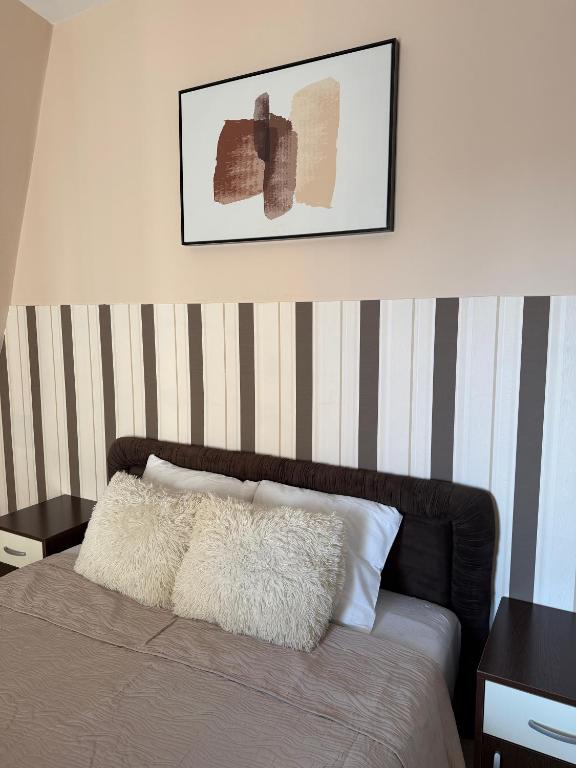 a bedroom with a bed with a striped wall at M Premium Apartments in Paraćin
