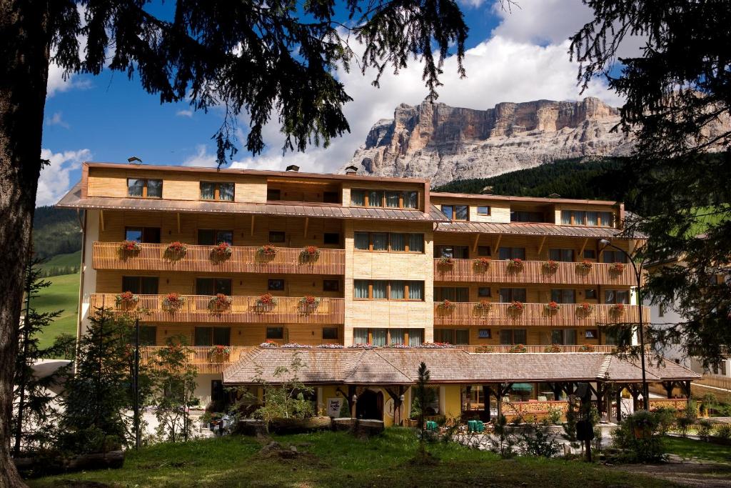 um grande edifício com uma montanha ao fundo em Hotel La Villa em La Villa