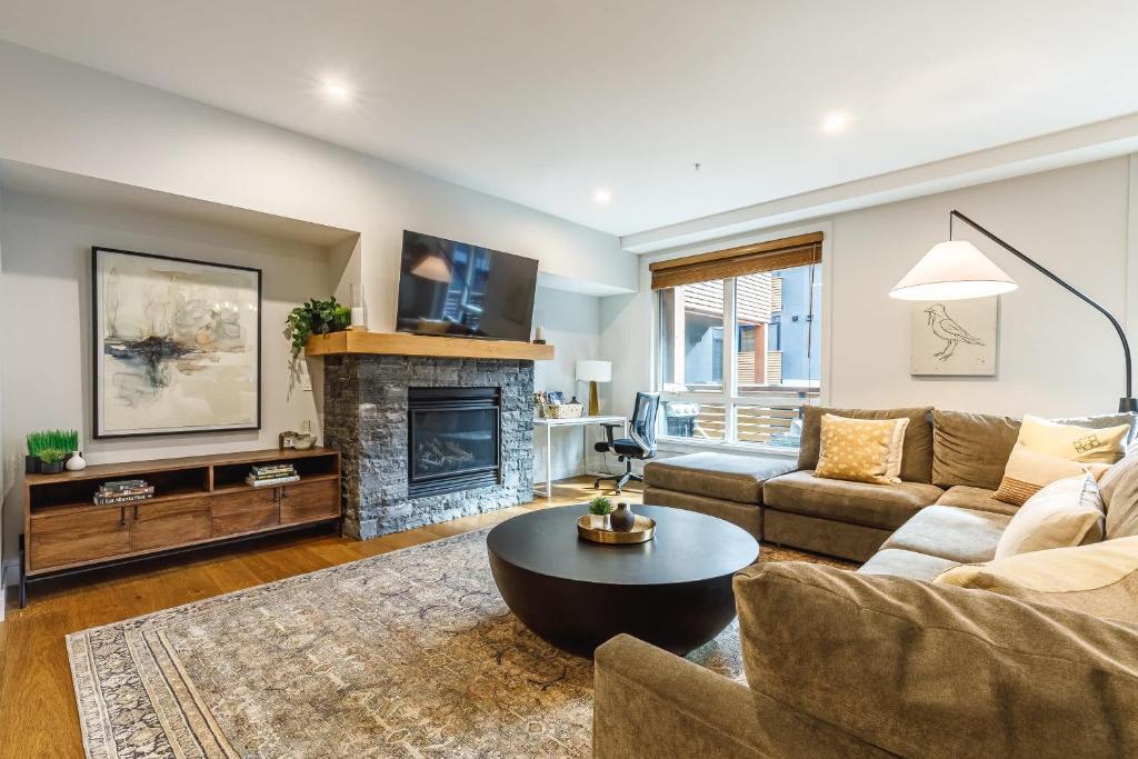 a living room with a couch and a fireplace at Inspired Elegance at Tamarack Lodge in Canmore