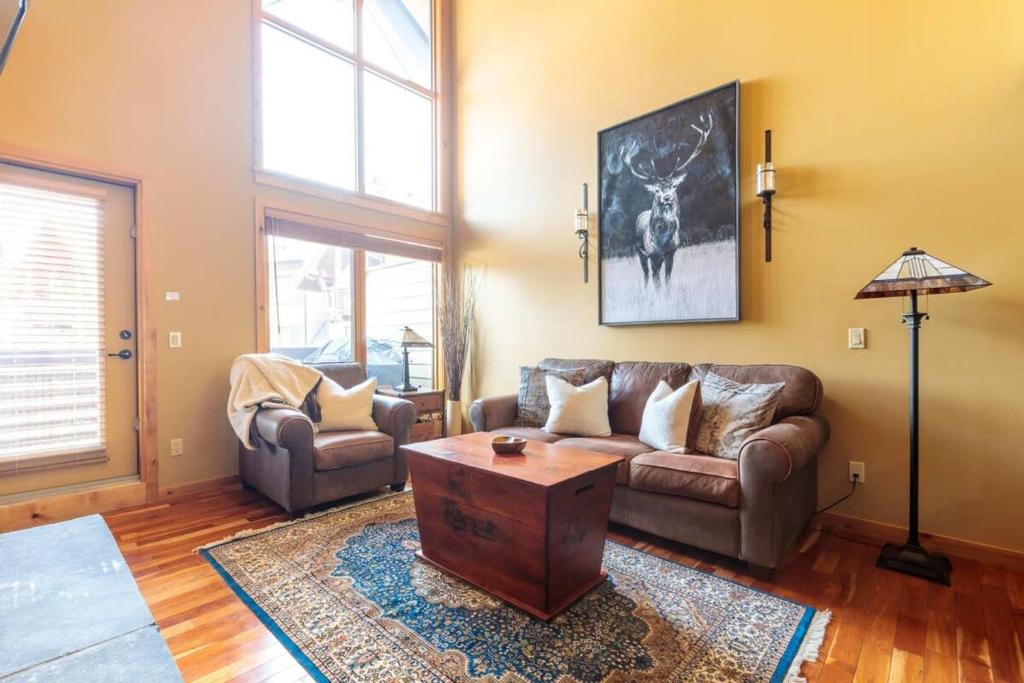 a living room with a couch and a table at Utopia at Rundle Cliffs Lodge in Canmore