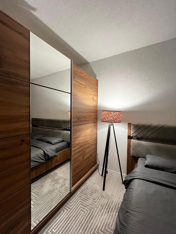 a bedroom with a mirror and a bed and a lamp at Cozy Central Corner in Gjakove