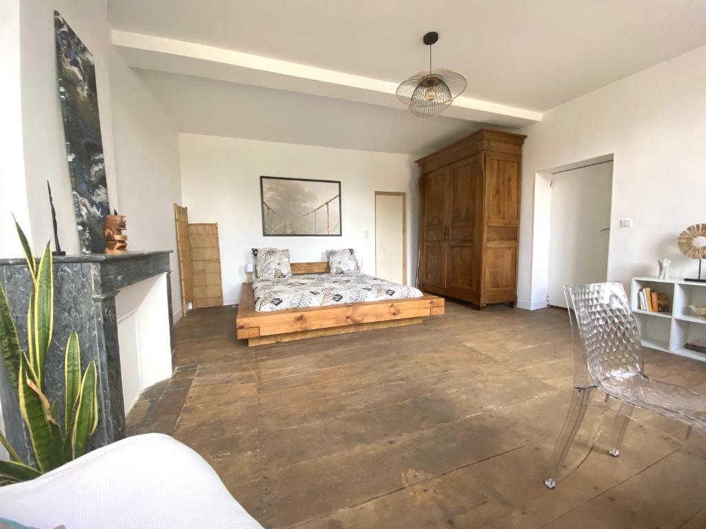 a living room with a bed and a fireplace at Chambre zen in Châteauneuf-sur-Charente