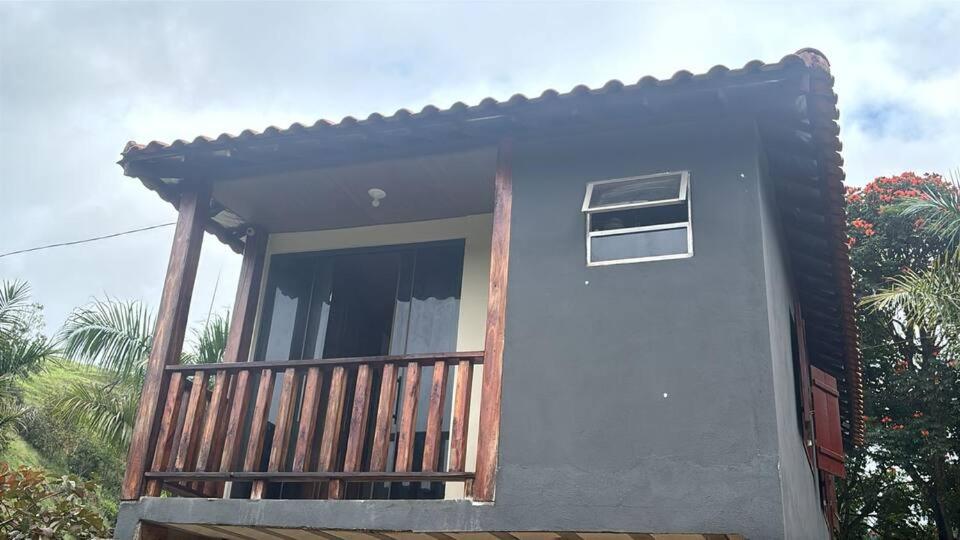 a house with a porch and a balcony at Chalé do Vicente in Ouro Preto