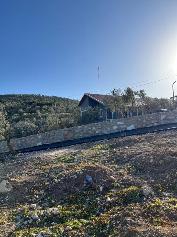 a road in a field with a house in the background at Suf Hills Cabin in Jerash