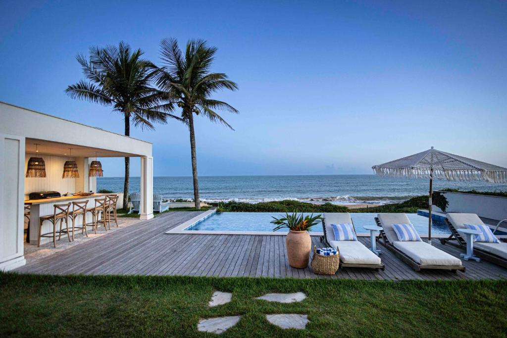 a villa with a swimming pool next to the ocean at Casa Praia Parati in Anchieta