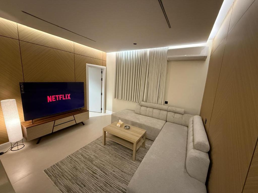 a living room with a couch and a tv at رولارا بلازا in Medina