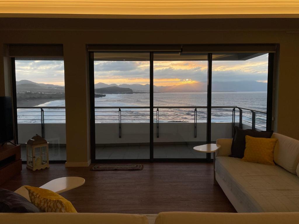 a living room with a view of the ocean at Azorean Sunset Loft 1 in Ribeira Grande