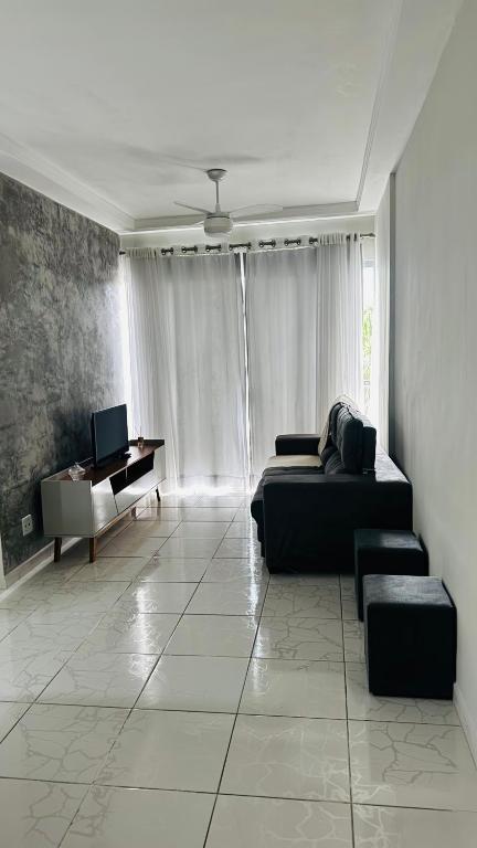 a living room with a couch and a piano at Costa Suite Enseada in Guarujá