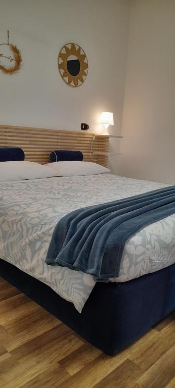 a bedroom with a bed with a blue blanket on it at Cristel Malpensa apartment in Cardano al Campo