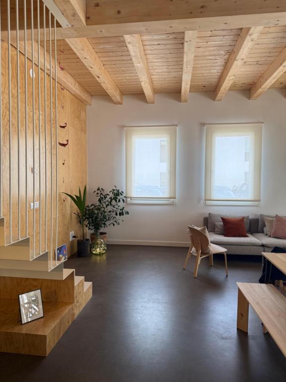 a living room with wooden ceilings and a couch at El Santo Hostel in Burgos