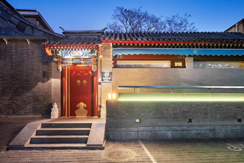 a building with a red door and a stairway at Liuli Tile Courtyard Hotel Houhai Tian Anmen Wangfujing in Beijing