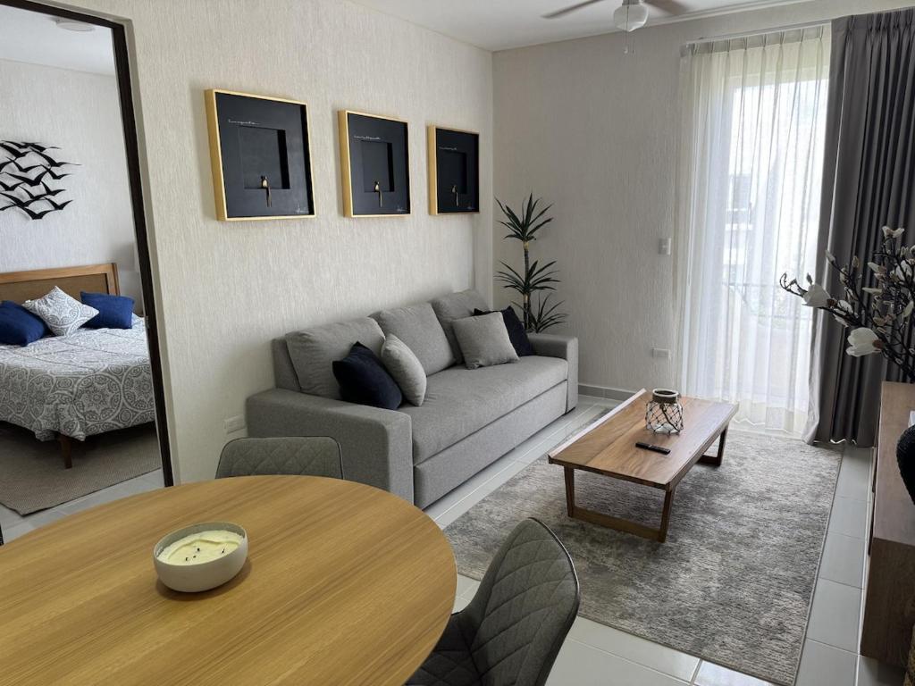 a living room with a couch and a table at Comfortable 2BR Condo pool & gym in Tulum
