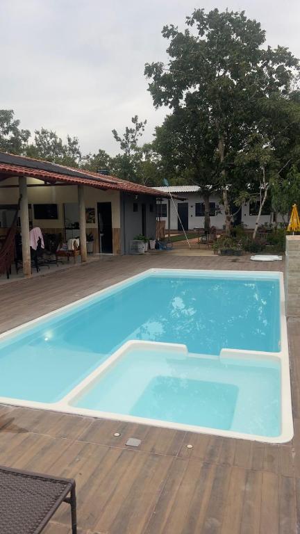 a large blue swimming pool next to a house at Casa do Lago Serra da Mesa - Niquelandia in Niquelândia
