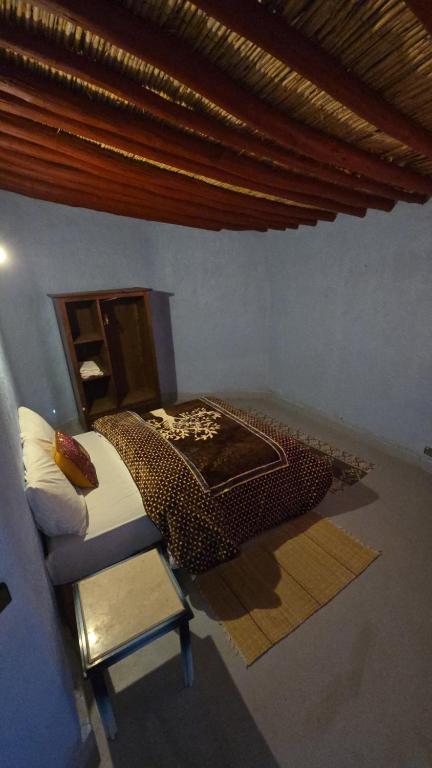 a bedroom with a bed and a chair in a room at ecolodge bivouac des aigles in Ouarzazate