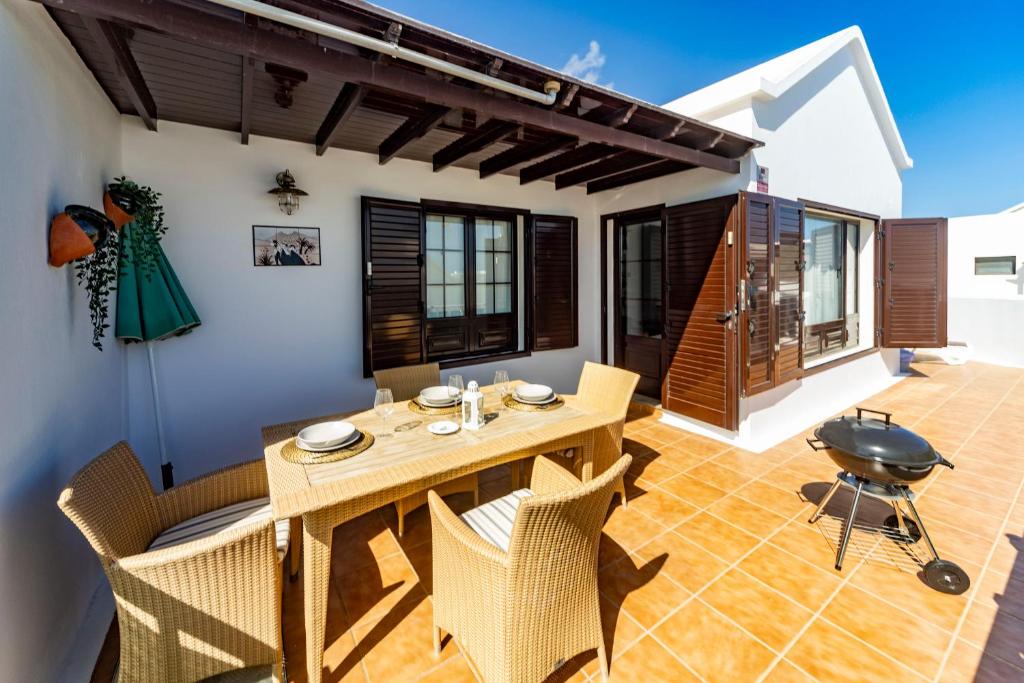 a dining room with a table and chairs and a grill at Luxury House Sofie in Tías