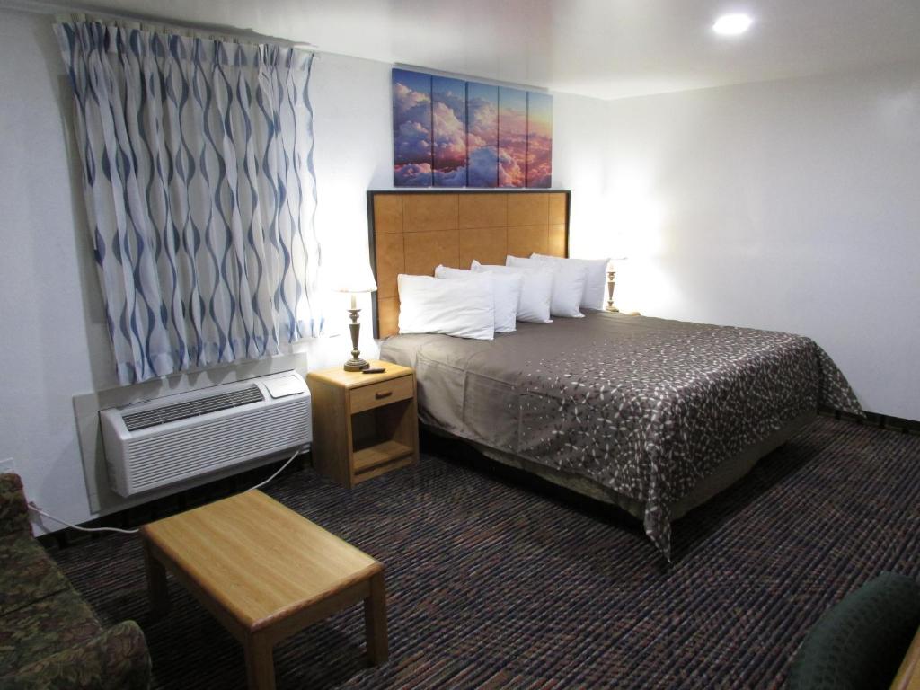 a hotel room with a bed and a tv at Parsons Inn Downtown Parsons,Tn in Parsons