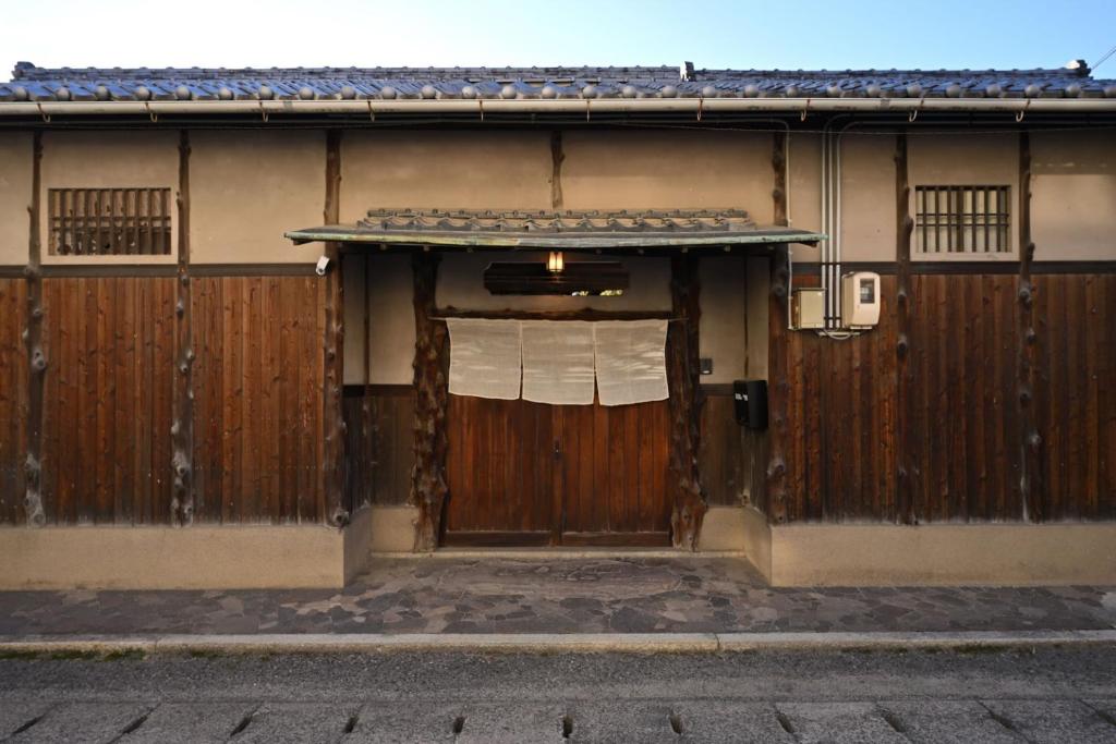 a building with a wooden door with a window at The Nomad Inn Yugejima in Kami-yuge