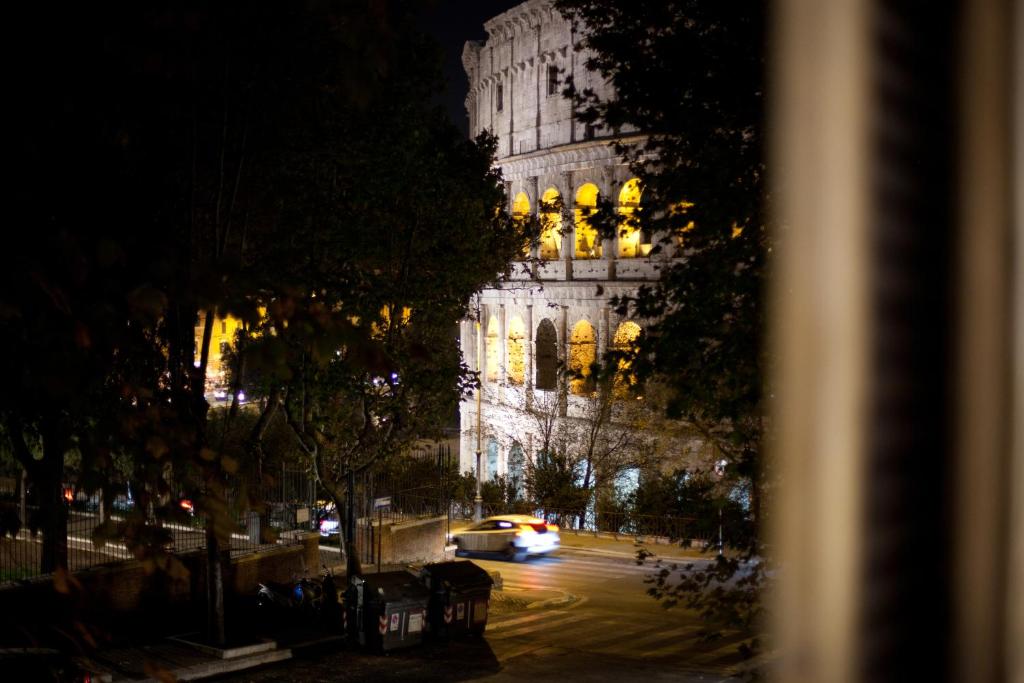 een auto die 's nachts langs een groot gebouw rijdt bij Maison Imperiale in Rome