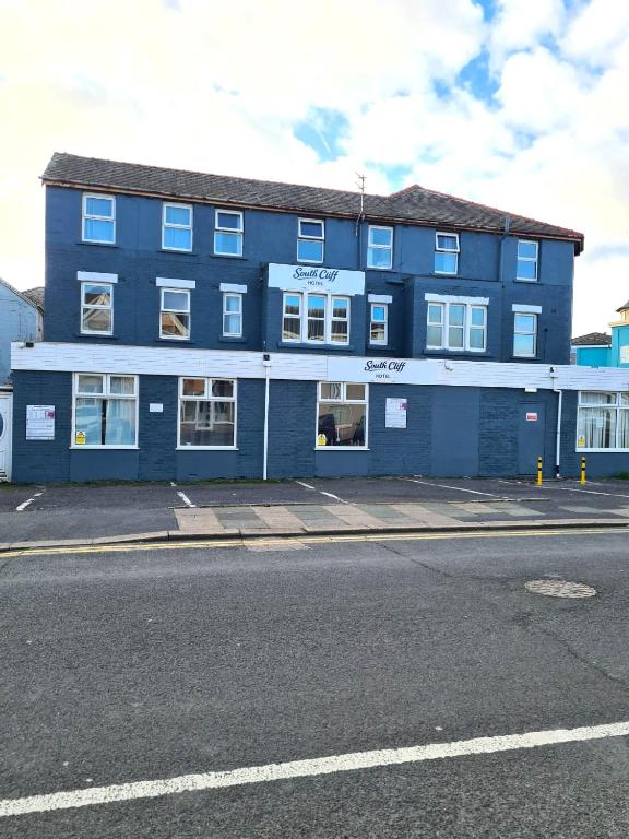 a blue building on the side of a street at South Cliff Hotel in Blackpool