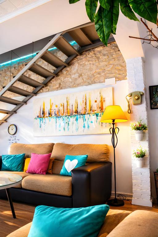 a living room with a couch with colorful pillows at La Casica del Abuelo Valentín in Torreblascopedro
