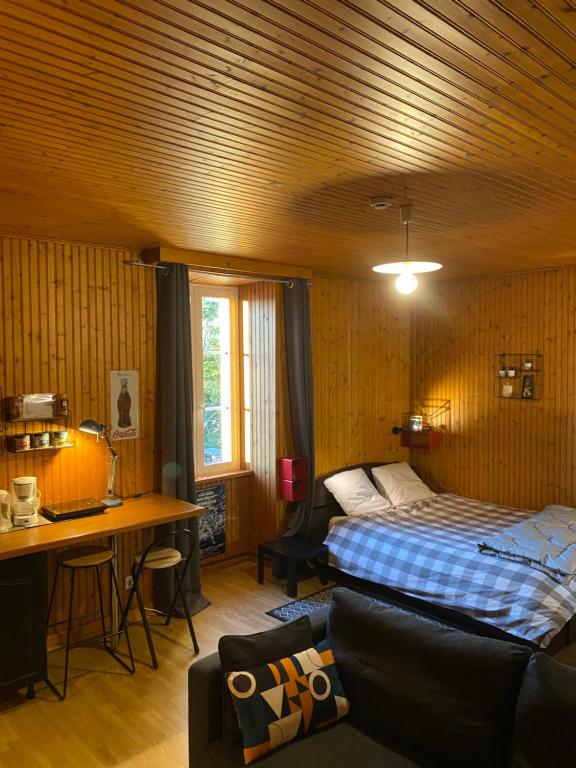a bedroom with a bed and a desk and a couch at Studio vintage in Parthenay