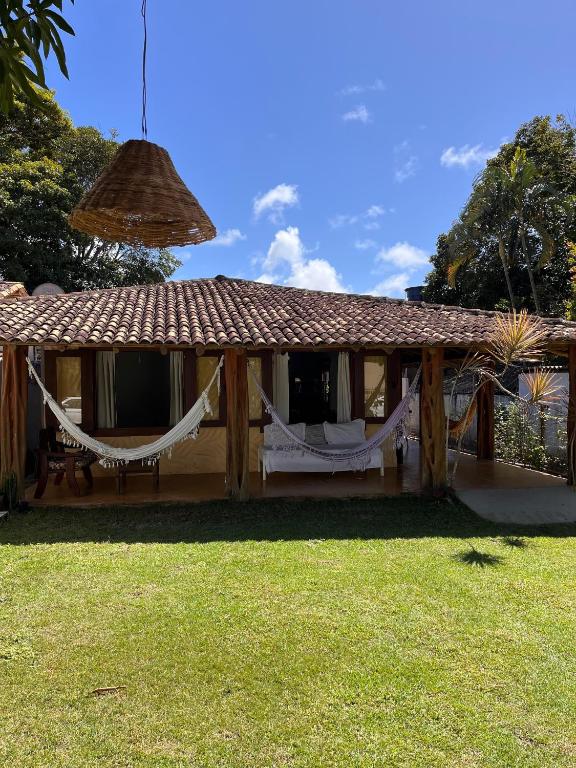 a house with hammocks in the yard at Casa Cris in Itaúnas