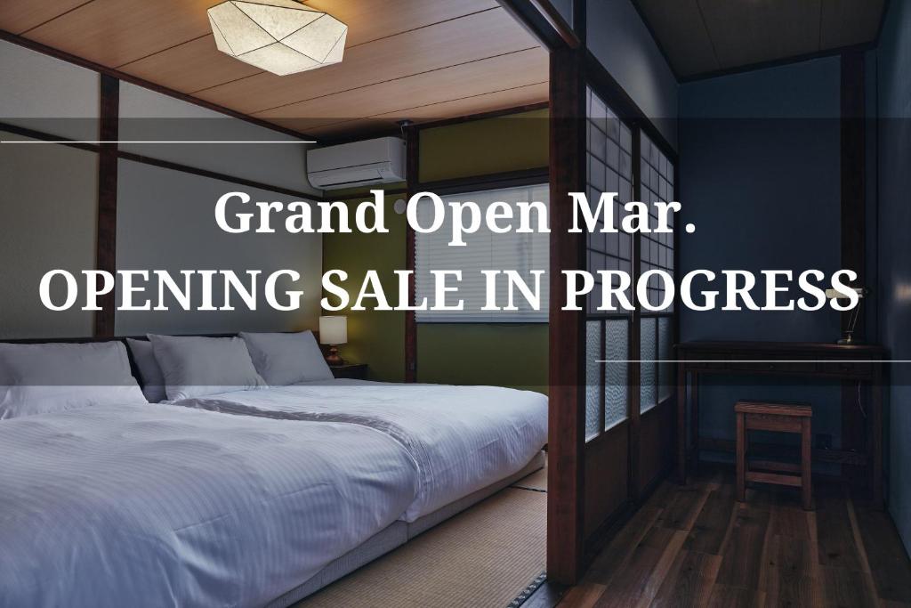 a bedroom with a bed with a sign grand open war operating sale in progress at 白金はなれ in Susakiuramachi