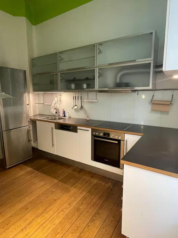a kitchen with white cabinets and stainless steel appliances at Zentrales & gemütliches Zimmer in Lübeck