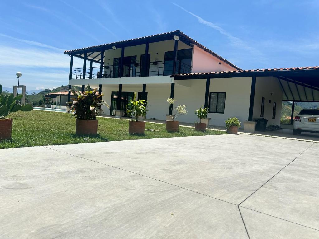 a large building with potted plants in front of it at Finca Villa AlCon - Hostel in Pereira