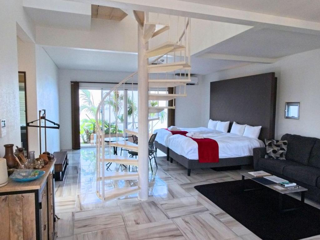 a bedroom with a bed and a staircase in a room at abundance okinawa & Kourijima Sauna resort in Kouri