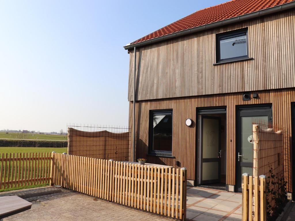 a house with a wooden fence in front of it at Luxury waterfront villa in Leons