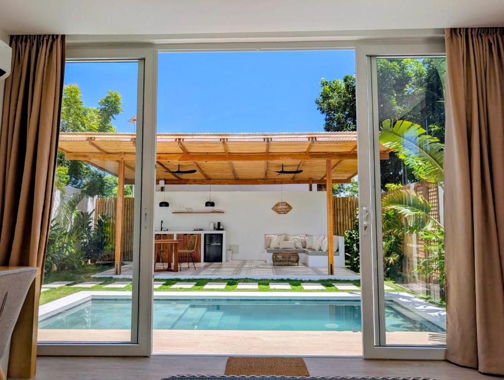 a house with a swimming pool and sliding glass doors at Villa Nindot - Private pool villas - Adults only in Siquijor
